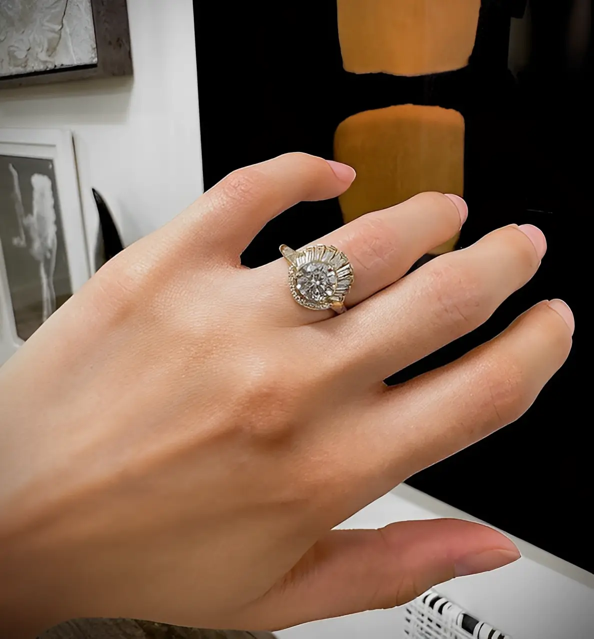 gold art deco inspired engagement ring on the finger