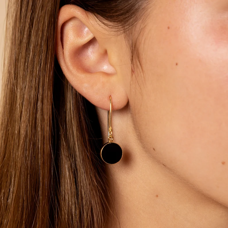 black obsidian and gold earrings on a woman's ear