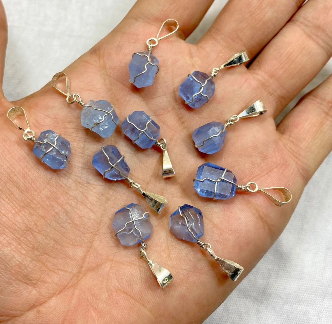 blue goshenite pendants on the palm