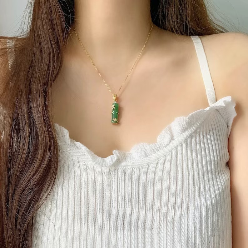 a woman wearing a jade bamboo pendant necklace