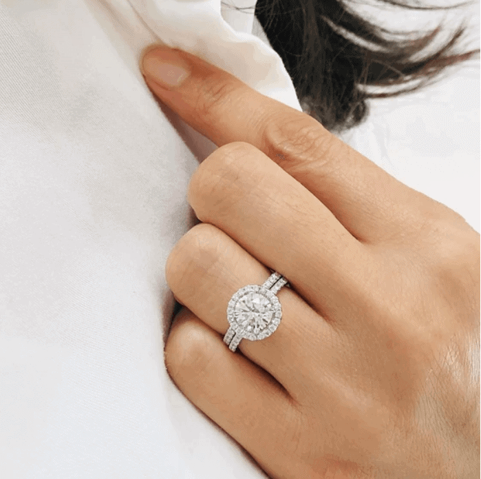 halo diamond engagement ring on the woman's ring finger