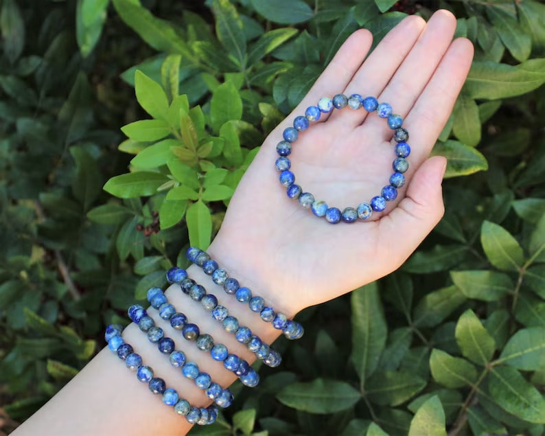 a hand with lapis lazuli beaded bracelets
