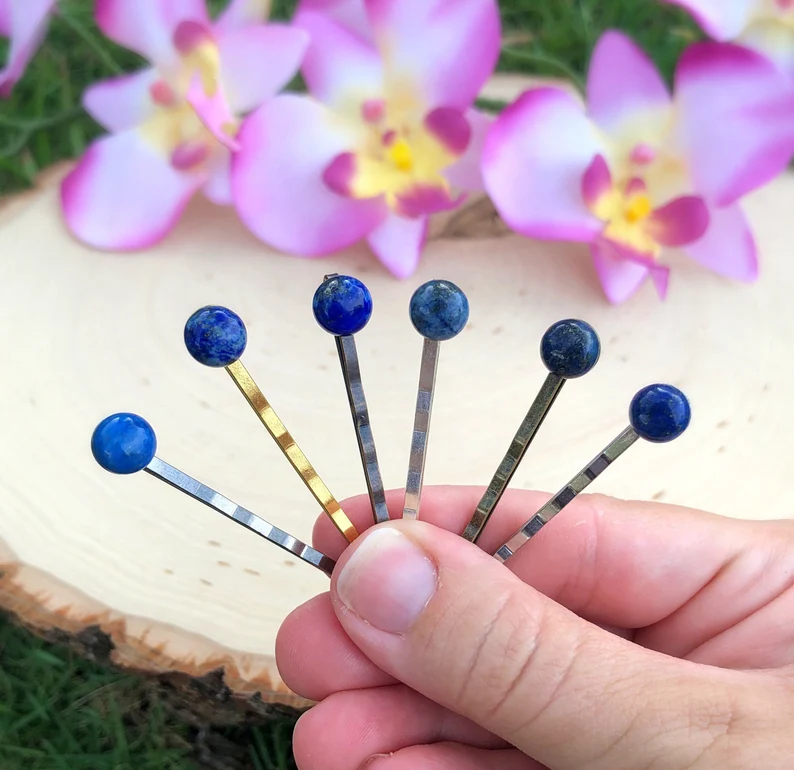a hand holding lapis lazuli hair pins