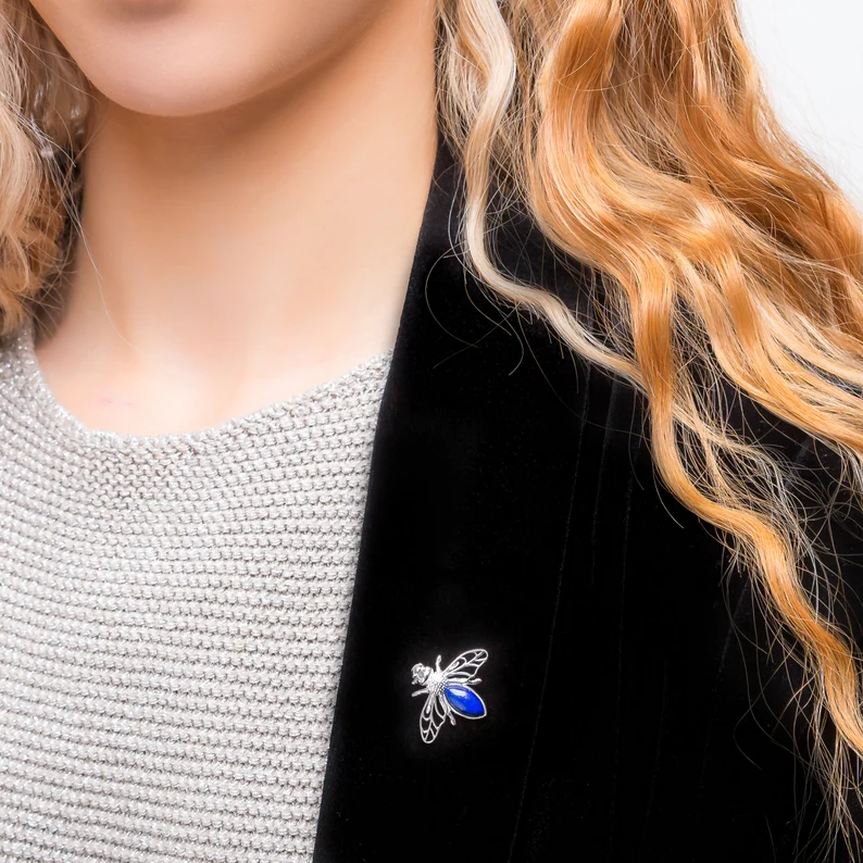 a woman with lapis lazuli honey bee brooch
