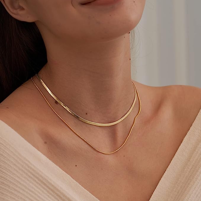 layered herringbone necklace on the woman's neck