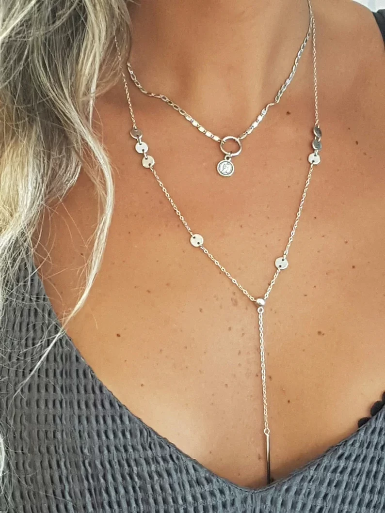 a woman wearing a layered lariat necklace