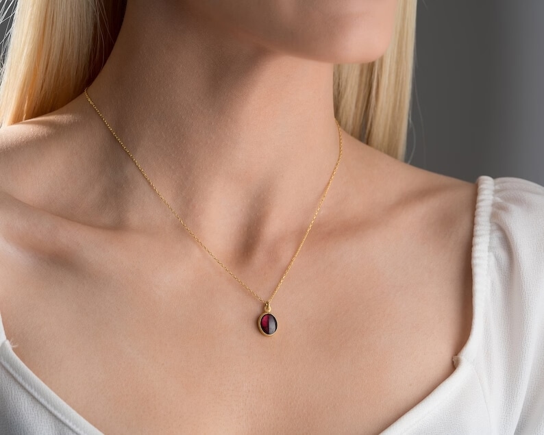 minimalist garnet necklace on a woman's neck