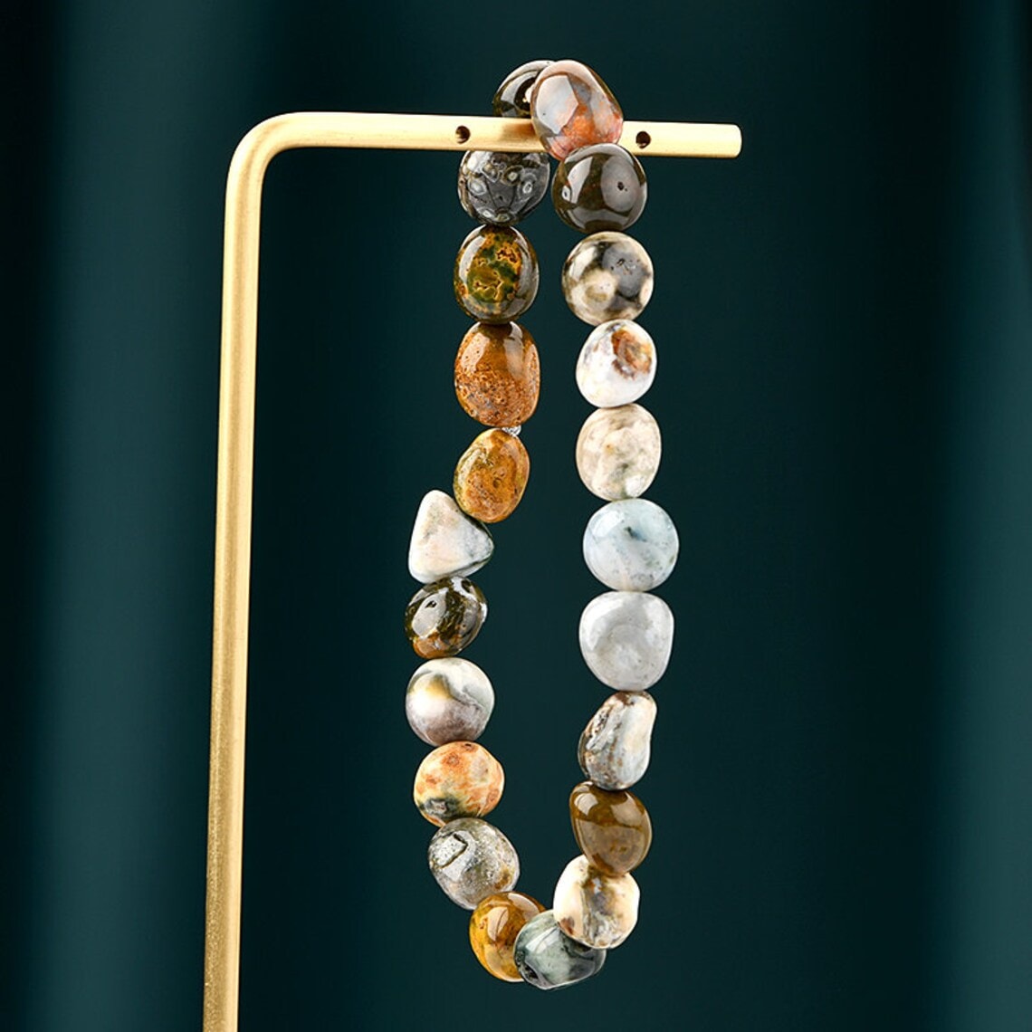 ocean jasper natural stone bracelet on a jewelry stand