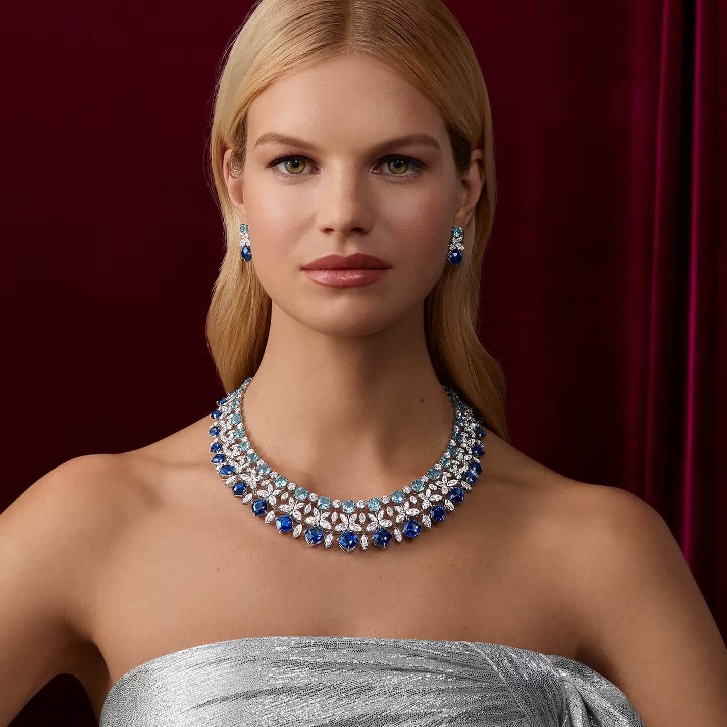 a woman wearing necklace and earrings with sapphires and diamonds