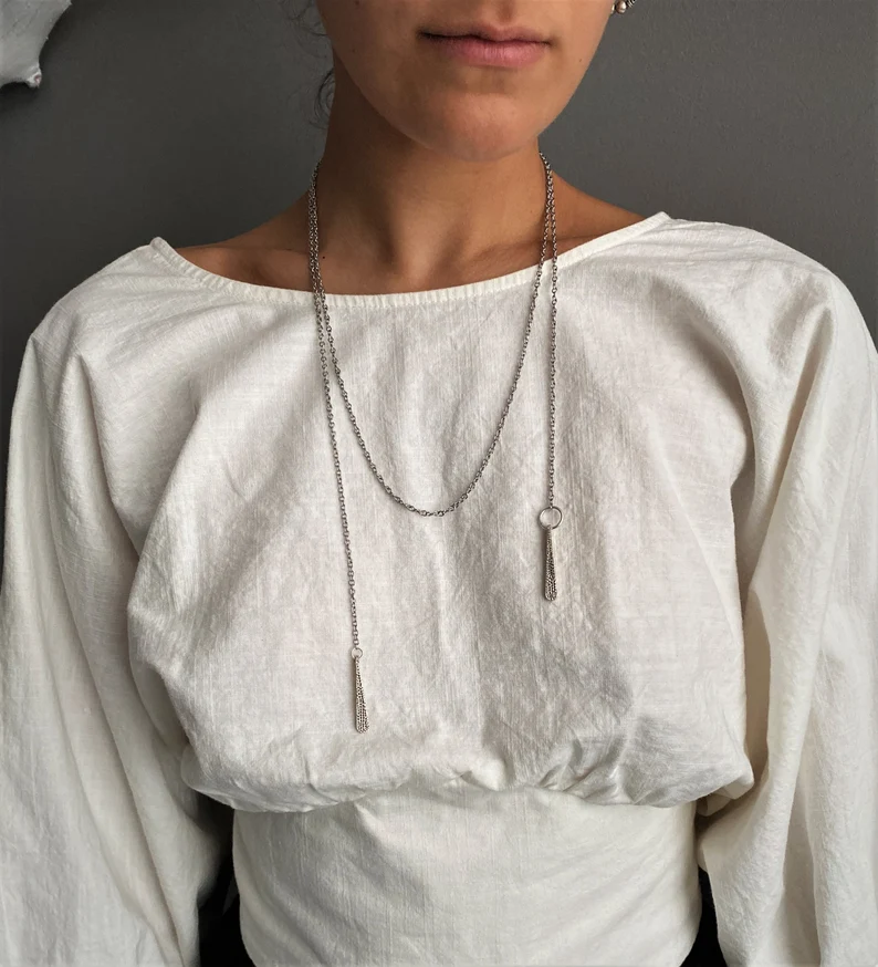 a wrap around lariat necklace on the woman's neck