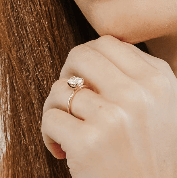 gold diamond engagement ring on the woman's ring finger
