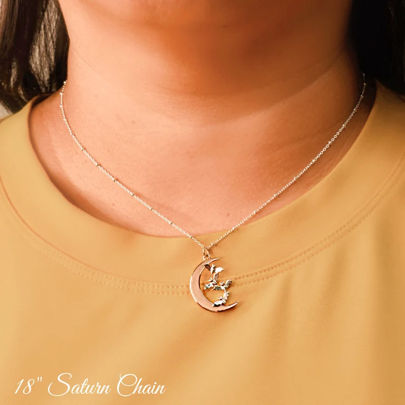 crescent moon bat necklace on the woman's neck
