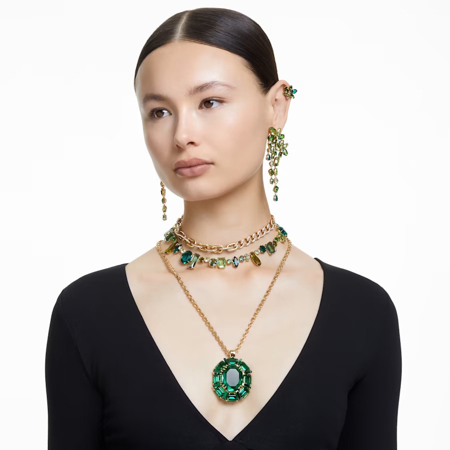 a woamn wearing green mixed cuts crystals jewelry