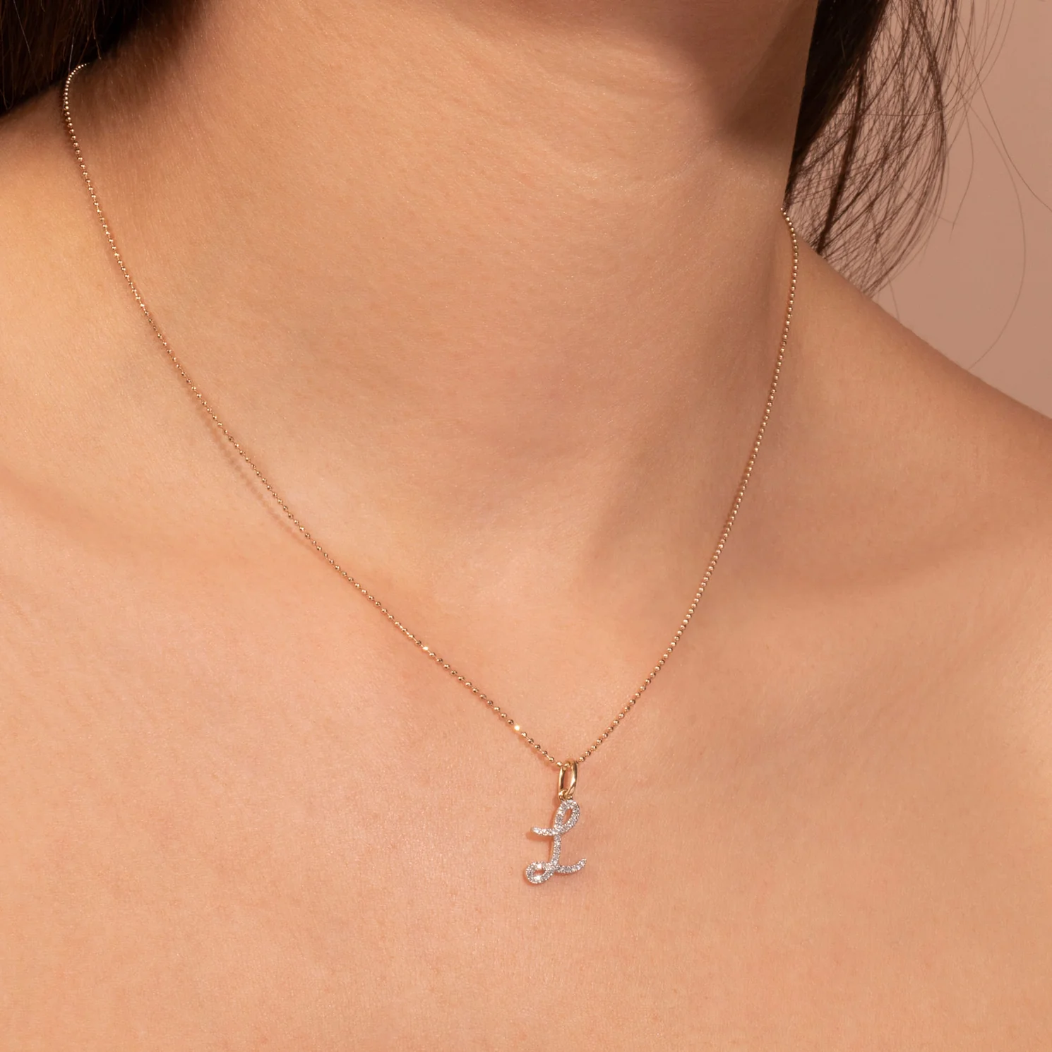 large pave scripted initial necklace on the neck