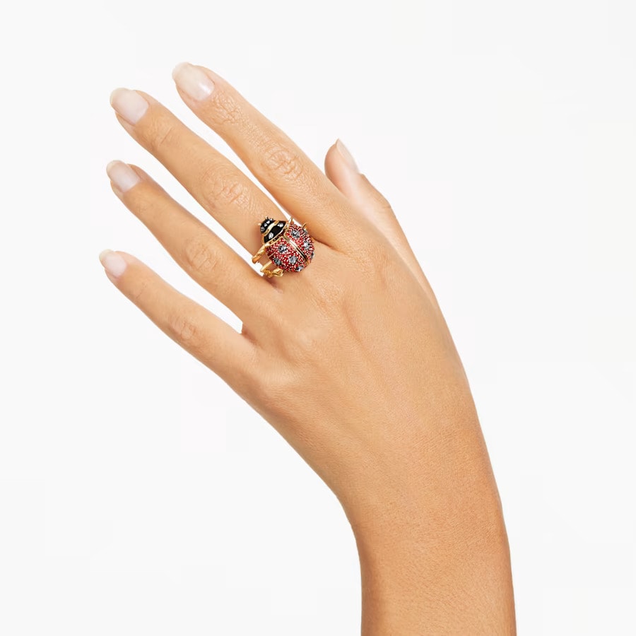 a red ladybug cocktail ring on the ring finger