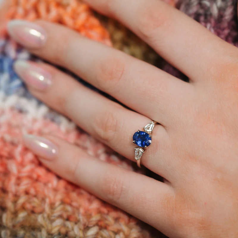 sapphire and diamond engagement ring on the woman's finger