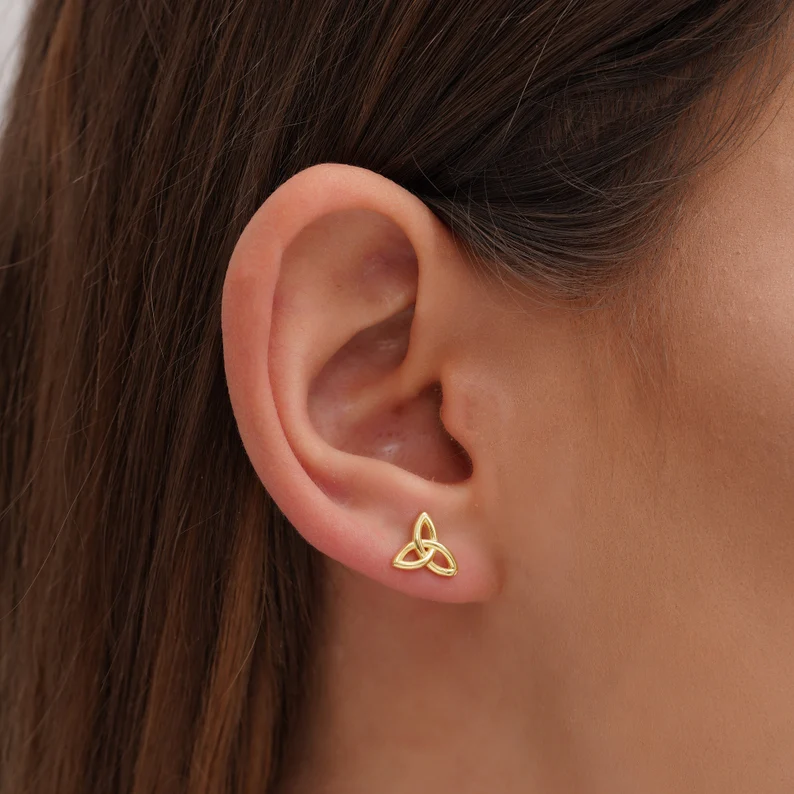 triquetra stud earring on the woman's ear