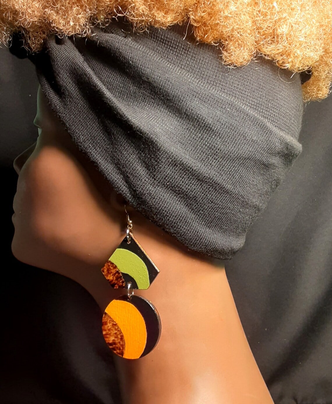 african modern wood earring on a mannequin's ear