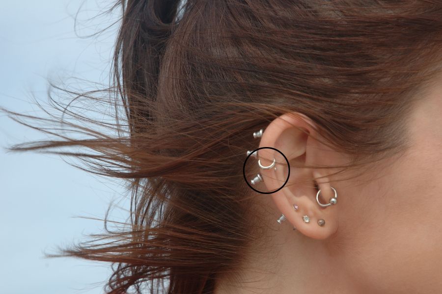 a woman's ear with auricle piercing