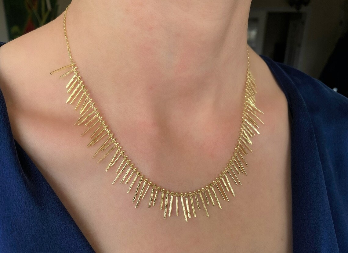 gold fringe necklace on the neck