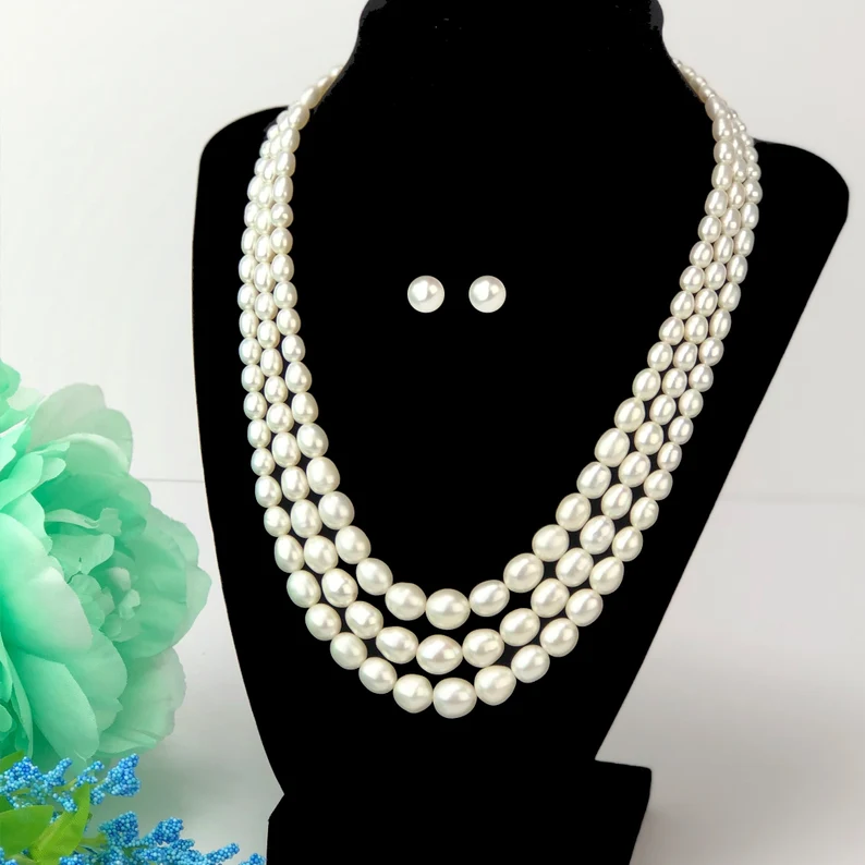 graduated bead pearl necklace and earrings on a neck mannequin