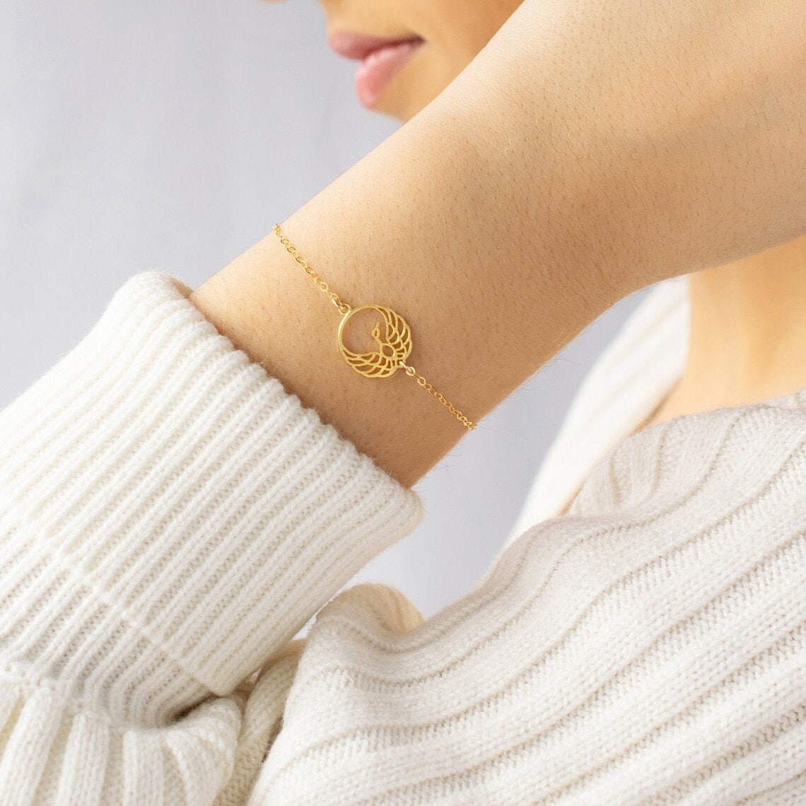 gold phoenix bracelet on the woman's wrist