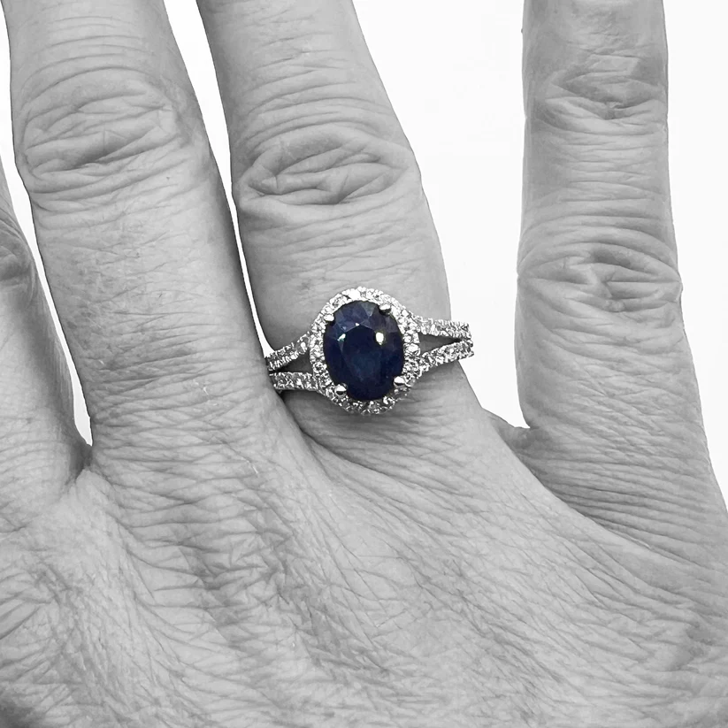 blue sapphire halo diamond ring on the ring finger