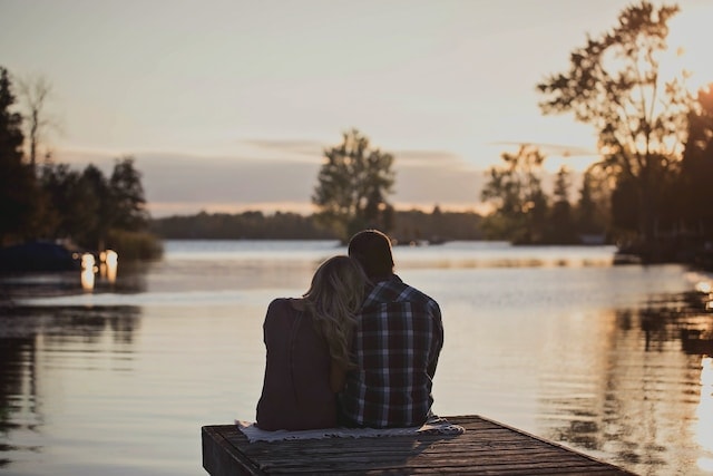 a couple sitting with each other with the lake view