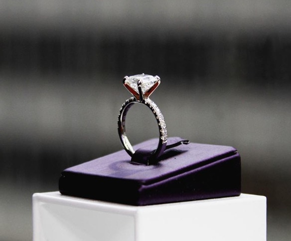round diamond engagement ring on top of a ring stand