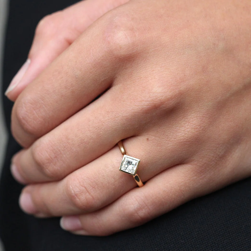 princess cut diamond engagement ring on the ring finger