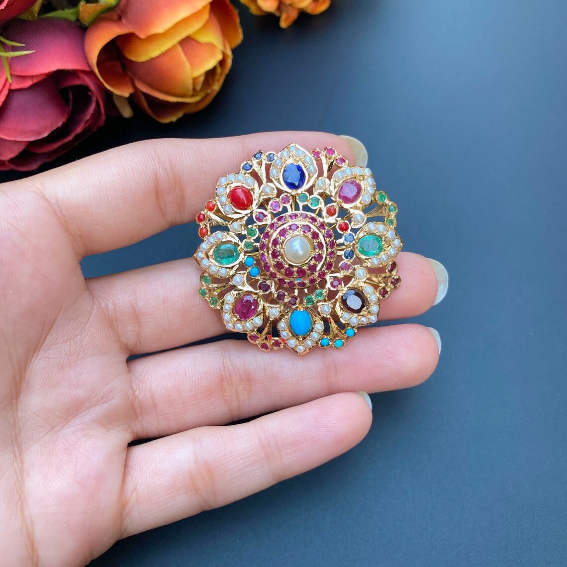 a hand holding a gold mughal ring