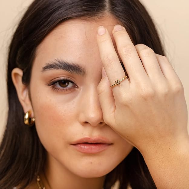 gold plated initial ring on the woman's finger