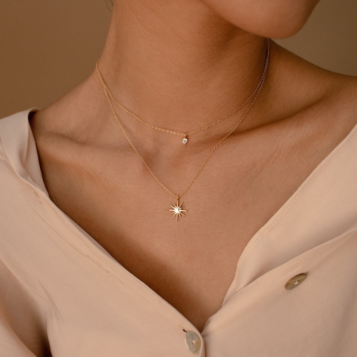 gold plated starburst necklace on the woman's neck