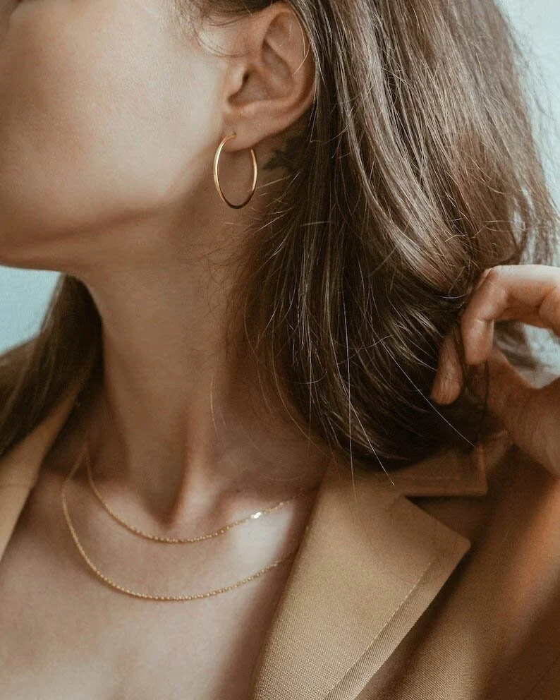 gold vermeil hoop earrings on the woman's ear