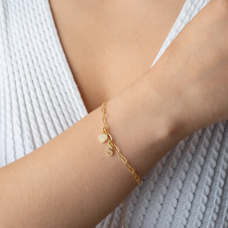 gold initial charm bracelet on the wrist